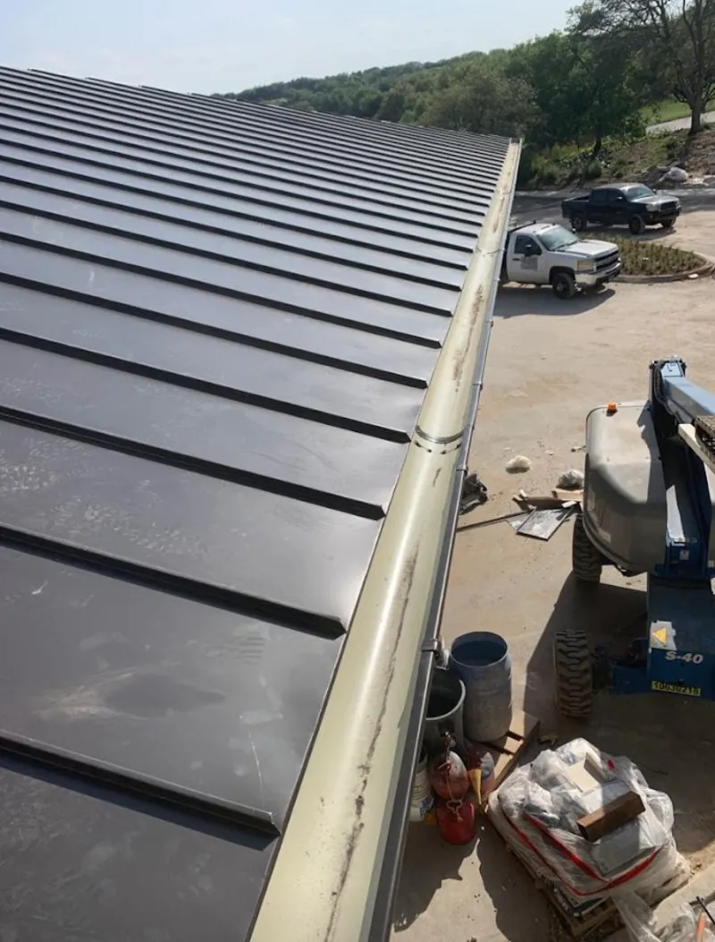 Standing seam panel and gutter detail on a metal roofing jobsite in Albion
